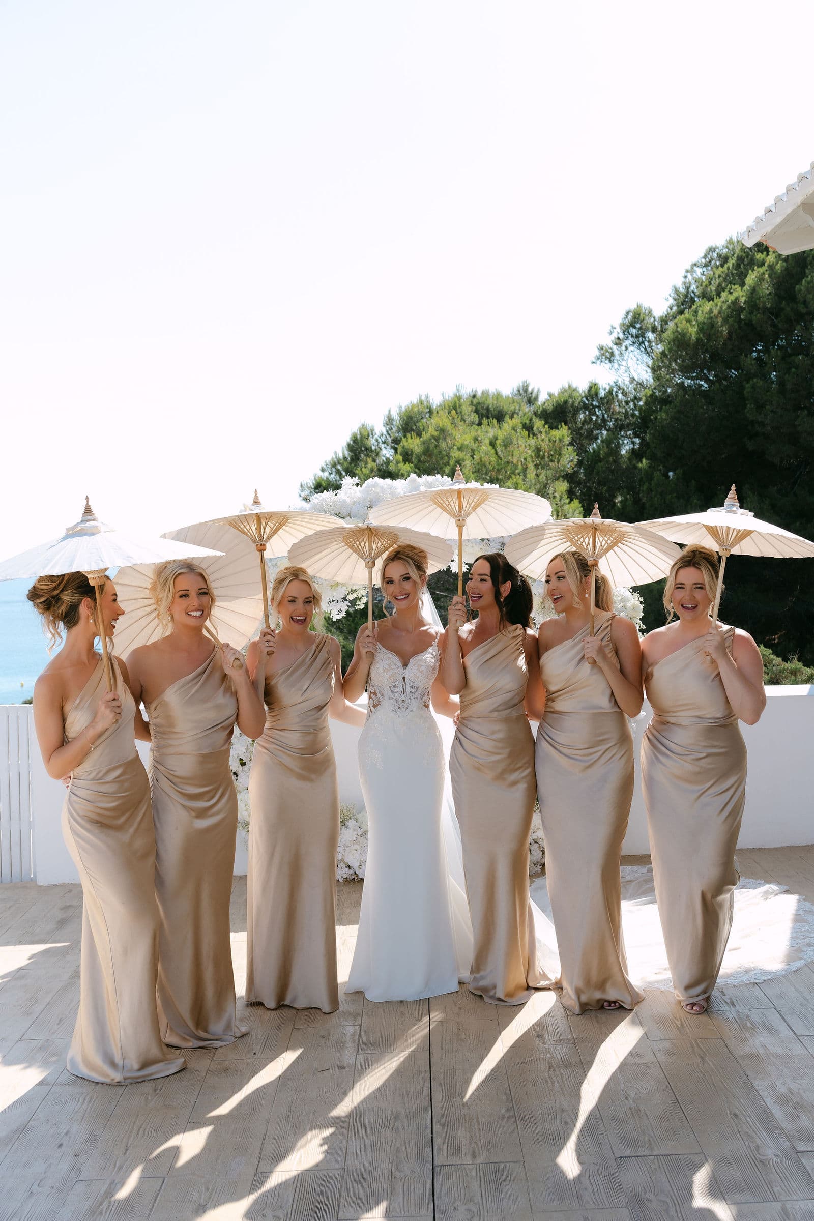 Bride and bridesmaids with parasols on the sun-kissed terrace at Elixir Ibiza