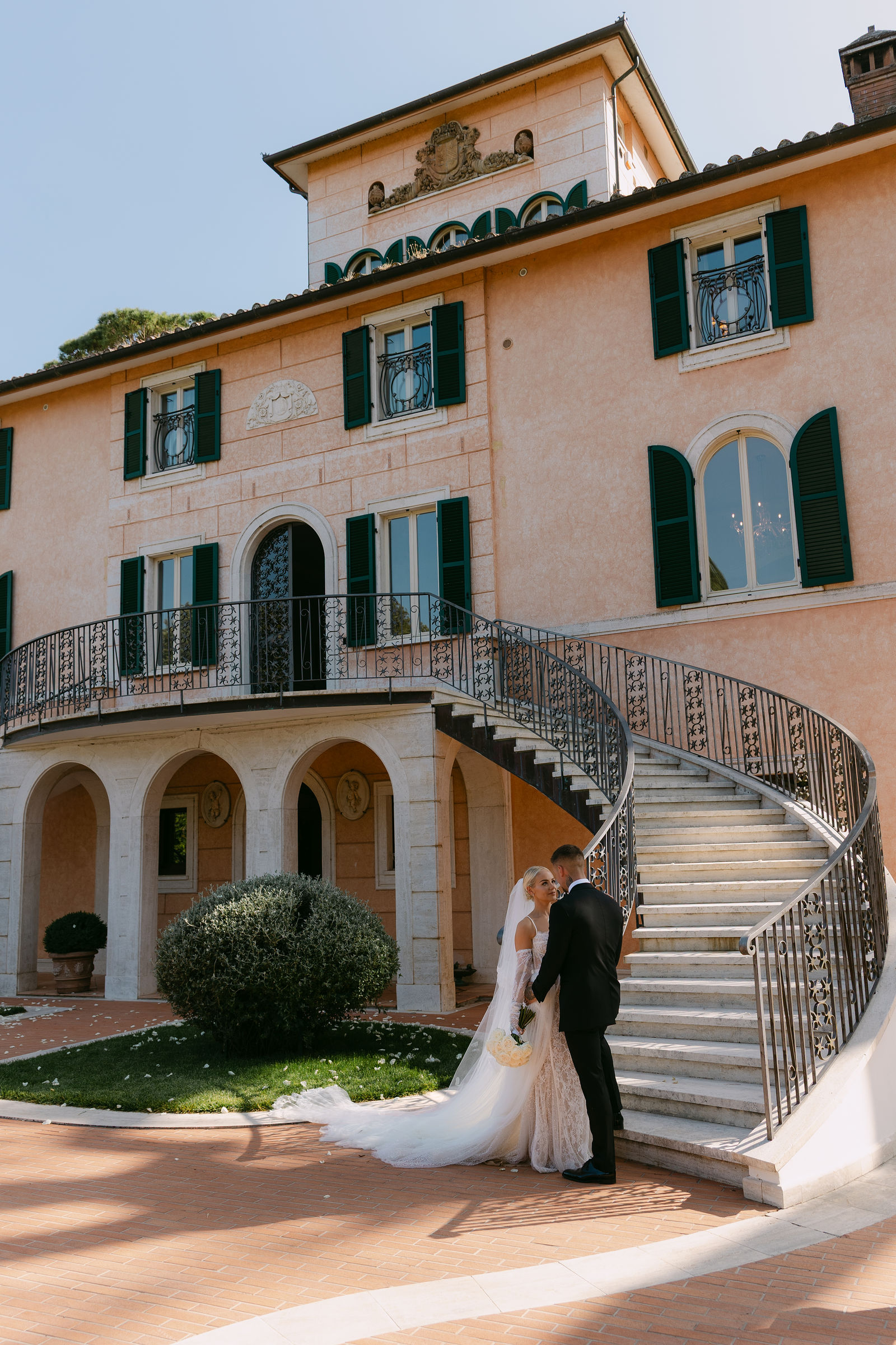 Newlywed couple at luxury Ibiza villa with grand curved staircase