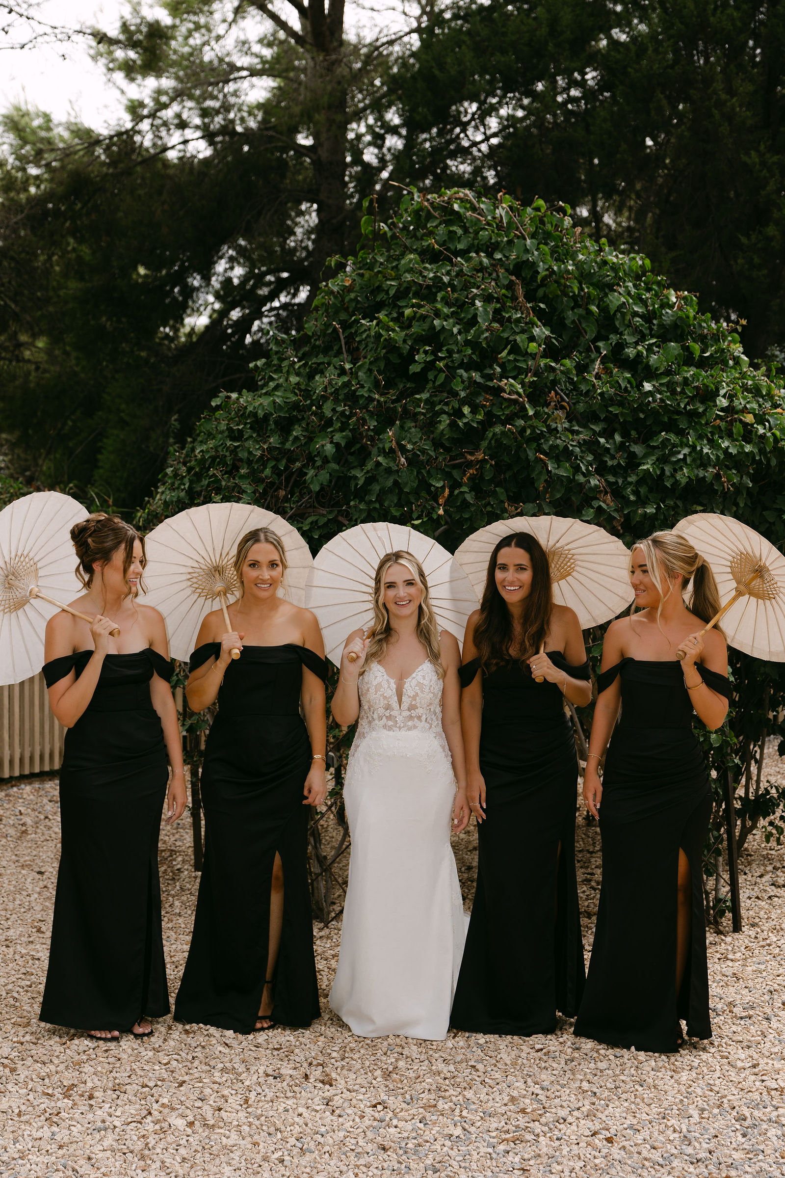 Bride with bridesmaids holding parasols at luxury Ibiza wedding